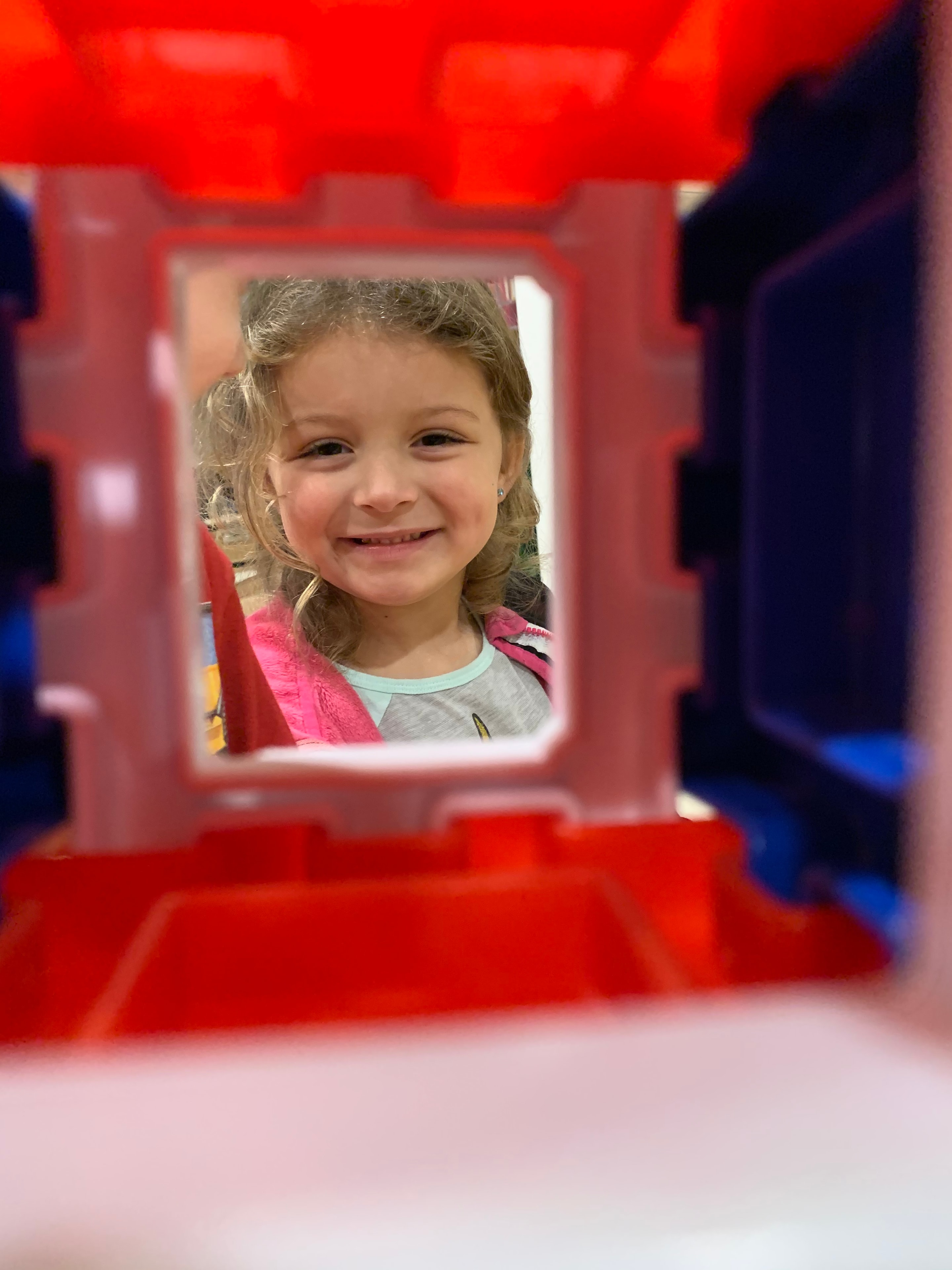 Pre-K child practicing writing letters at a classroom desk